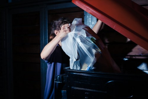 Waste disposal crew navigating tight local access beside a property