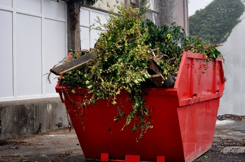 Local waste collection service tidying a car park and surrounding area