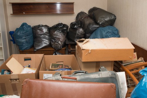 Professionals loading office furniture and waste into a removal vehicle